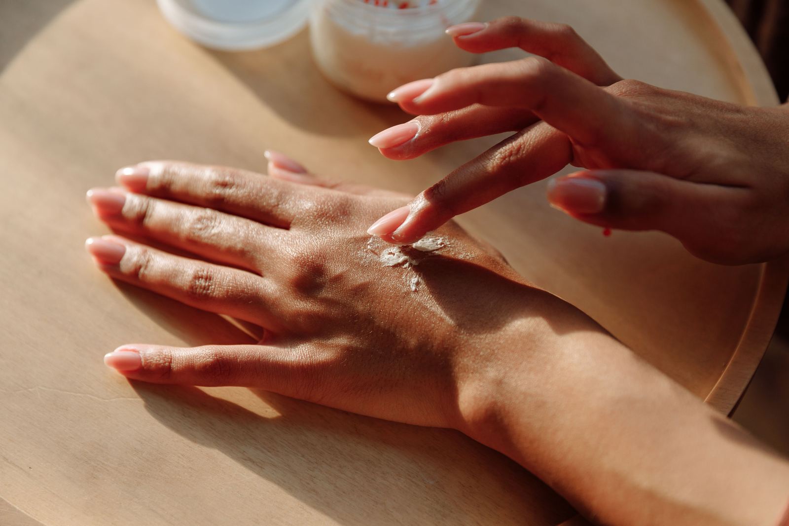 Hands gently applying sunscreen in warm golden light — making SPF part of the morning ritual