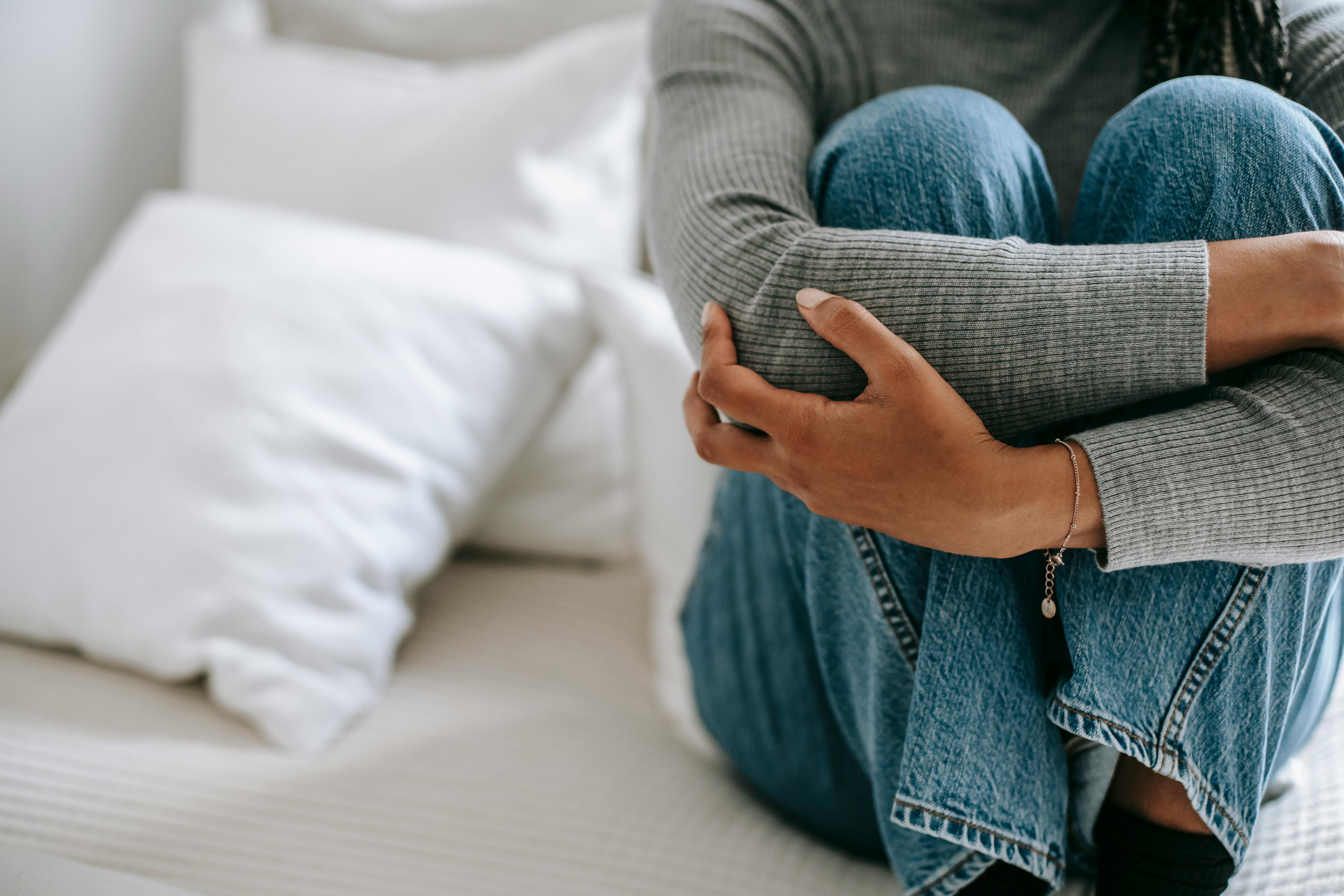 Woman hugging her knees, sitting quietly