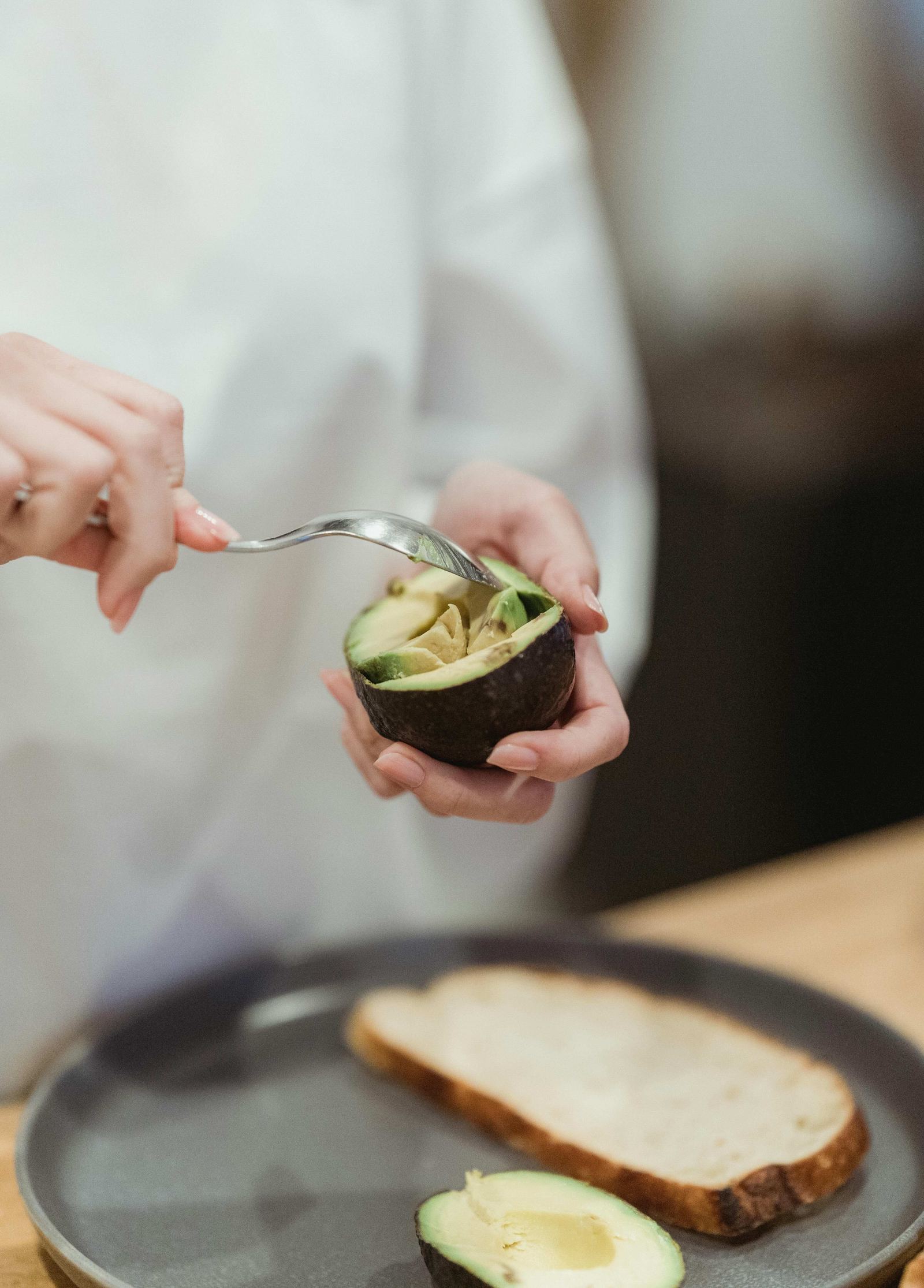 Hands scooping fresh avocado