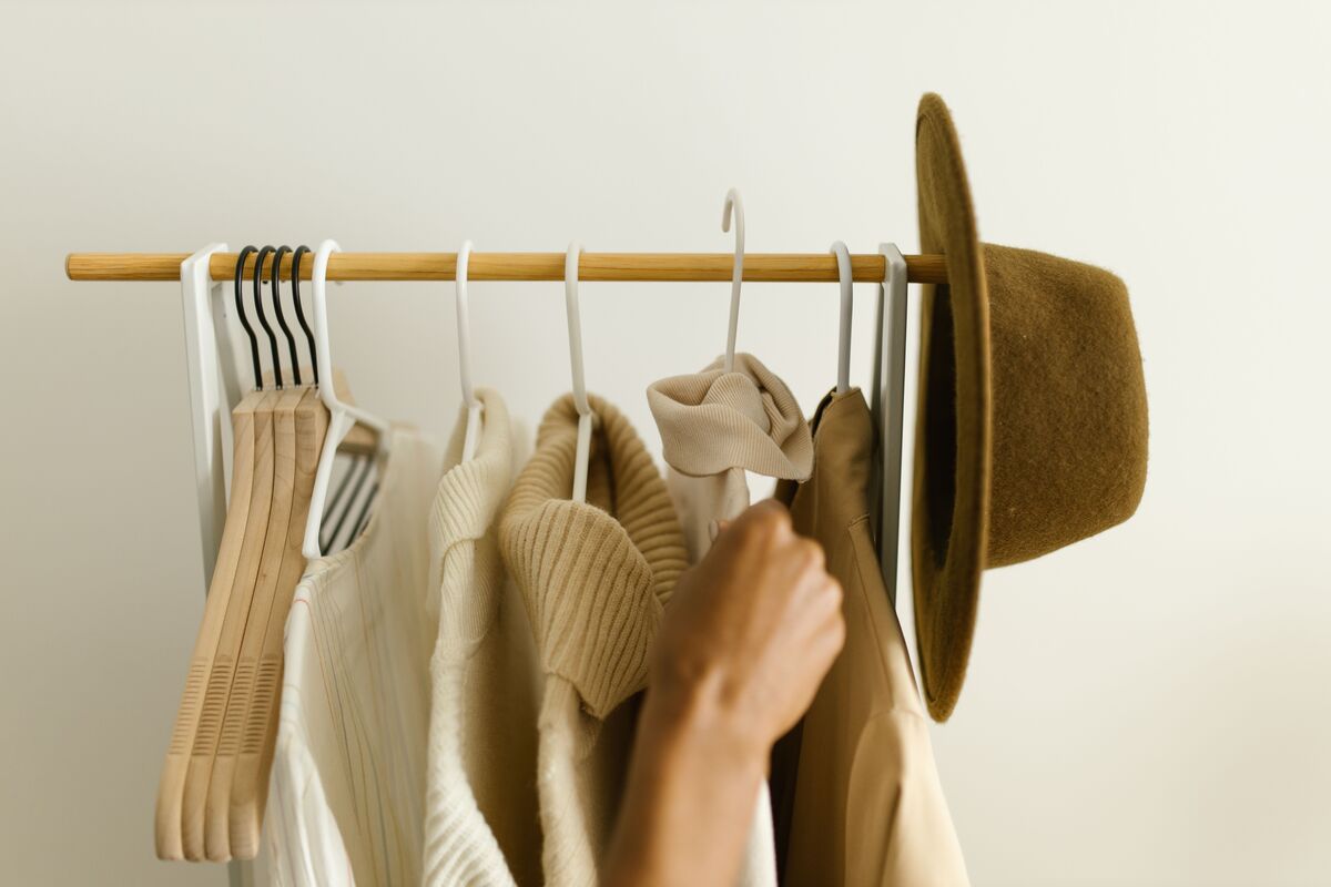 A small, considered wardrobe of natural fibers on wooden hangers