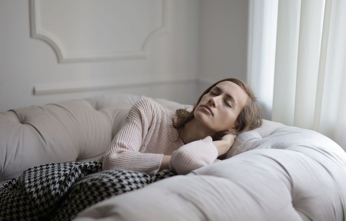 A woman resting on a sofa in warm afternoon light, unhurried