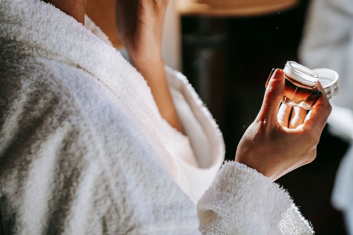 Skincare serums and a dropper bottle arranged on a bathroom shelf