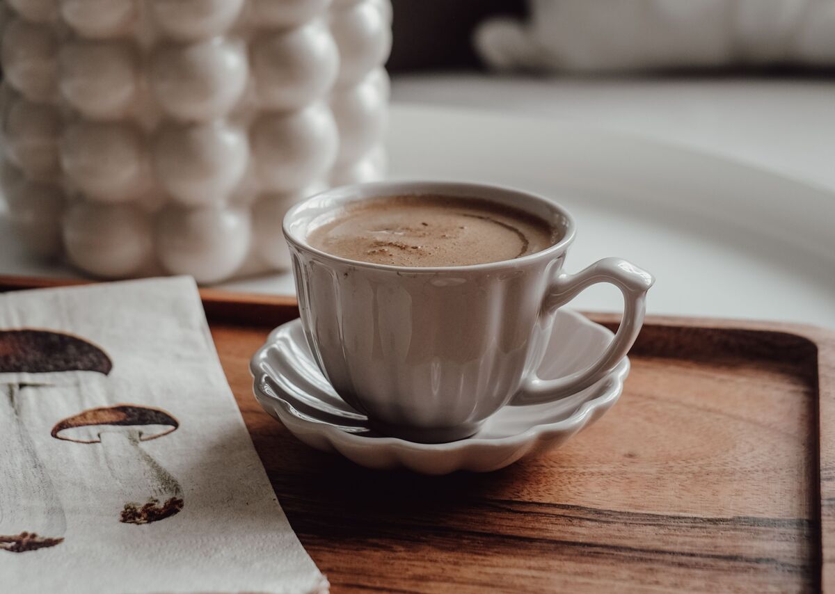 A cup of mushroom coffee with ground Lion's Mane and Chaga beside it