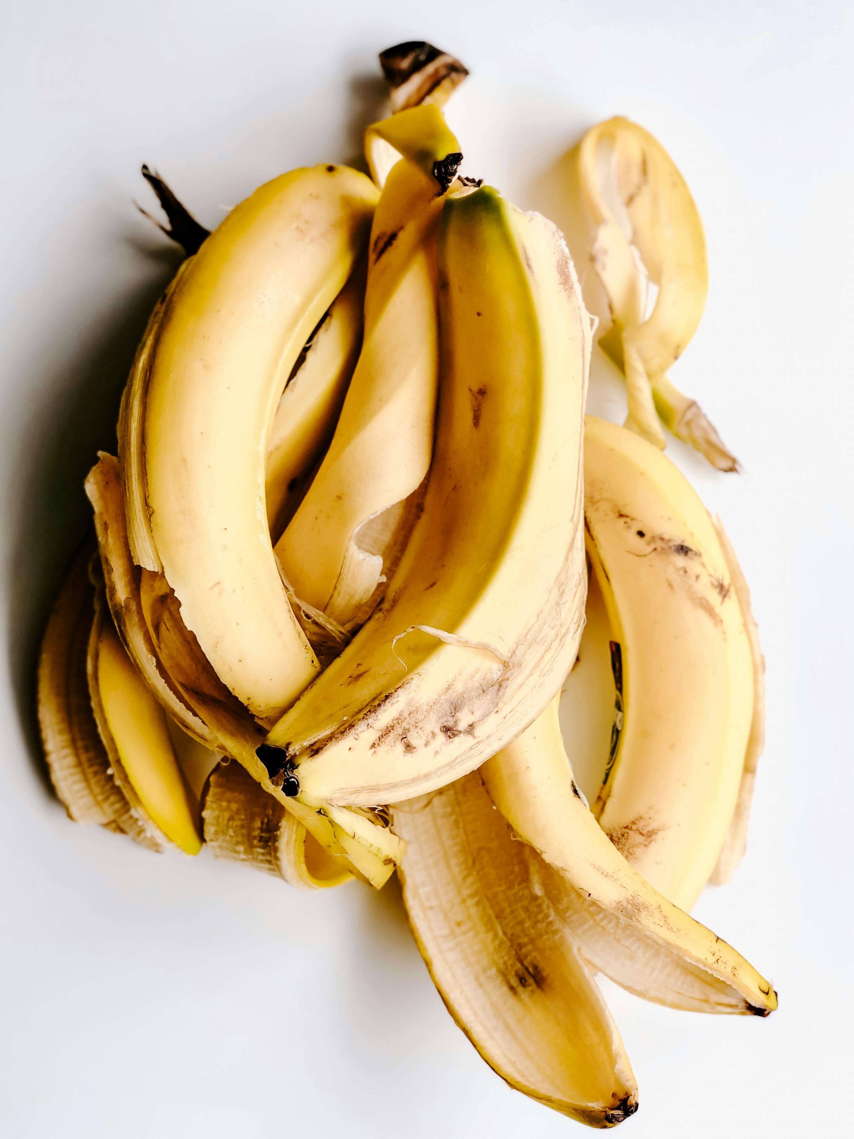 A pile of banana peels on a clean white surface, soft natural light
