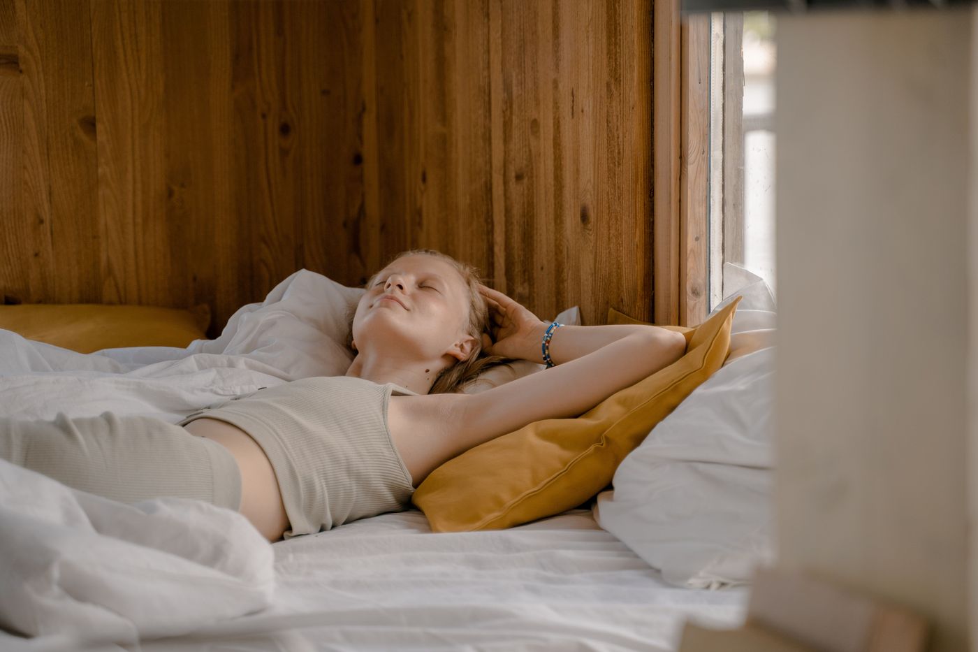 A woman resting quietly on a sofa in soft afternoon light