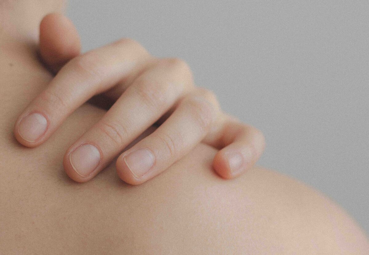 Minimal skincare flat lay — gentle cleanser, moisturizer, and SPF on a soft linen surface