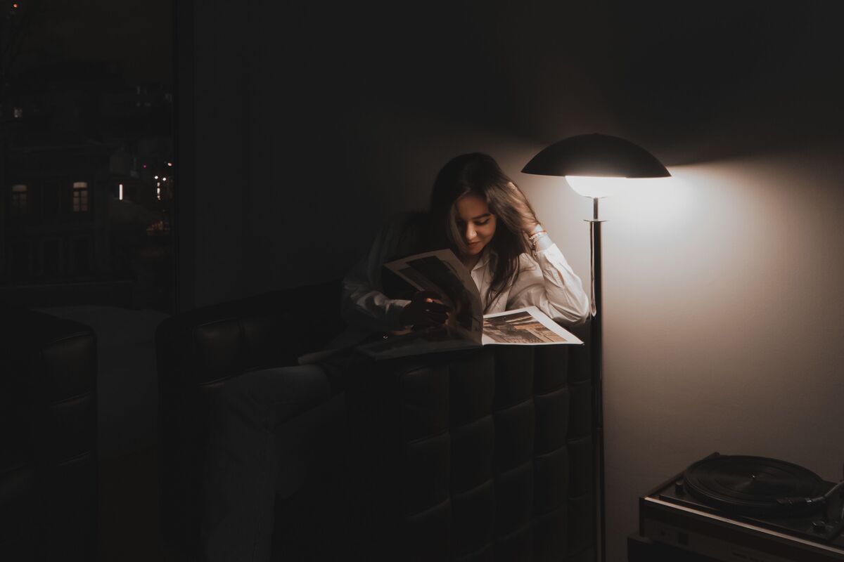 A notebook and pen on a table in low evening lamplight