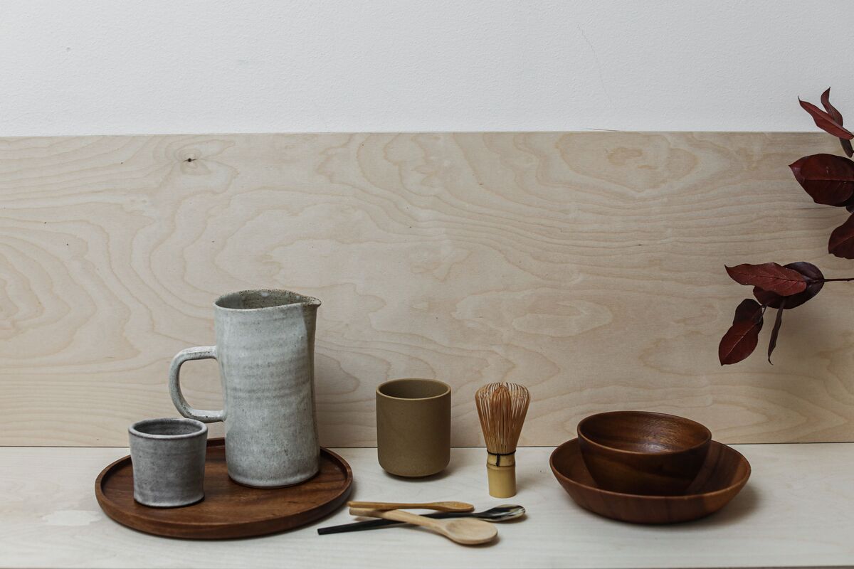 A worn wooden table with a linen cloth and simple hand-thrown ceramics