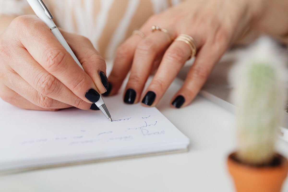 An open notebook and pen on a wooden table in warm daylight